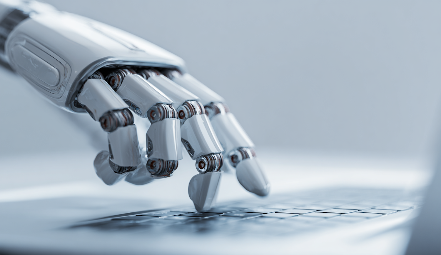 Robotic hand pressing a key on a laptop keyboard